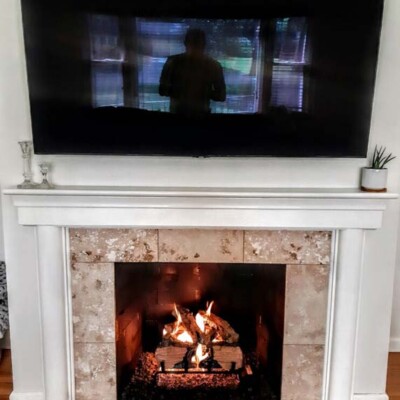 gas fireplace with marble tile and white mantle
